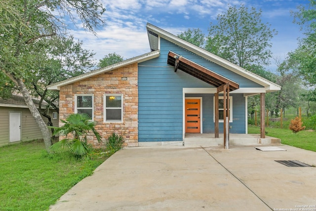 view of front of property featuring stone siding, a porch, and a front yard