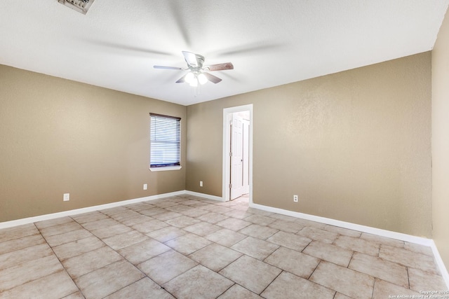 unfurnished room featuring ceiling fan, light tile patterned floors, visible vents, and baseboards