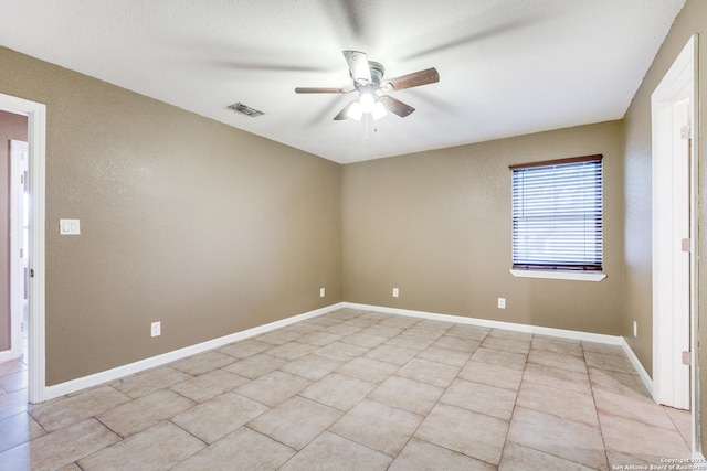 unfurnished room featuring baseboards, visible vents, a ceiling fan, and light tile patterned flooring