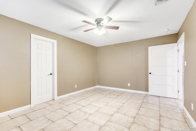 empty room with ceiling fan, visible vents, baseboards, and light tile patterned flooring