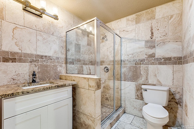 full bath with tile walls, toilet, a shower stall, and vanity