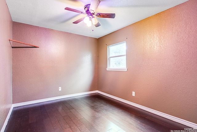 unfurnished room with ceiling fan, baseboards, dark wood-style flooring, and a textured wall