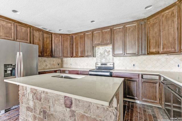 kitchen with stainless steel appliances, light countertops, dark wood-type flooring, and a sink