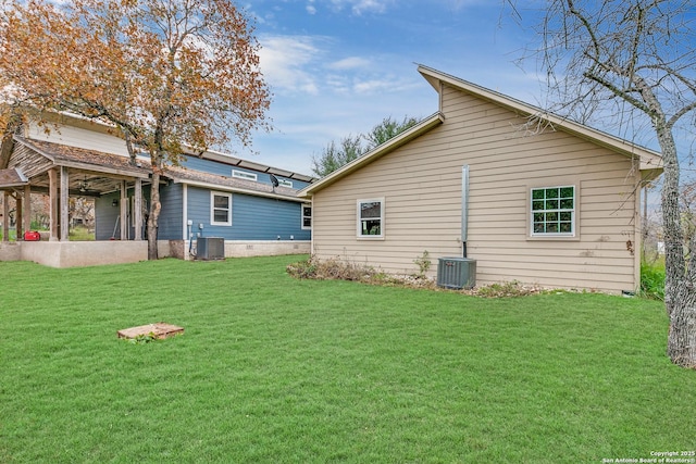 back of property with a yard and central AC