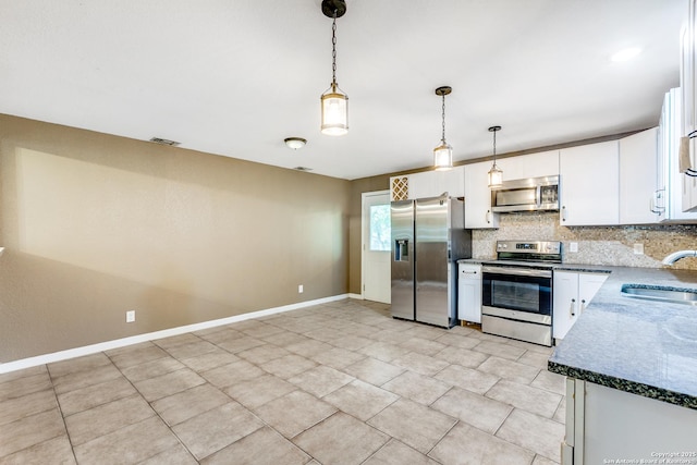 kitchen with stainless steel appliances, tasteful backsplash, a sink, and white cabinets