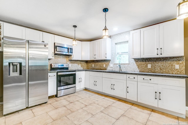 kitchen with appliances with stainless steel finishes, a sink, backsplash, and light tile patterned floors