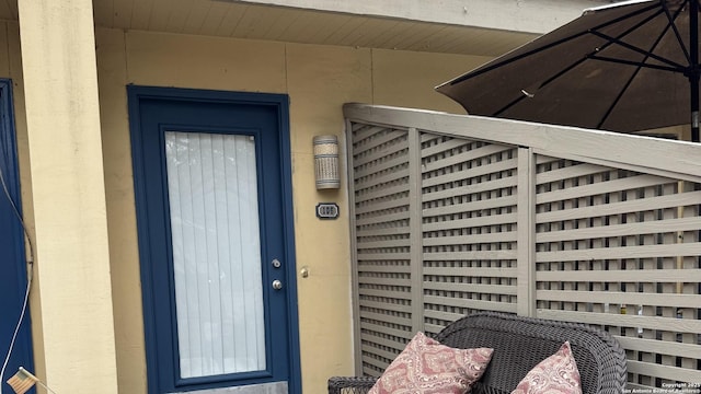 doorway to property featuring stucco siding