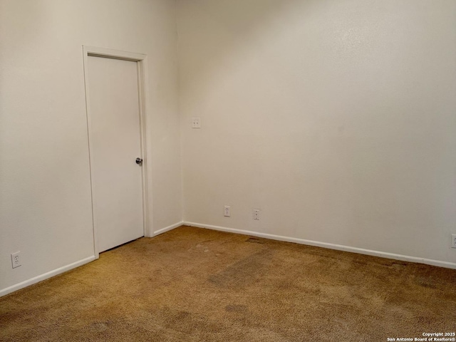 carpeted empty room featuring baseboards