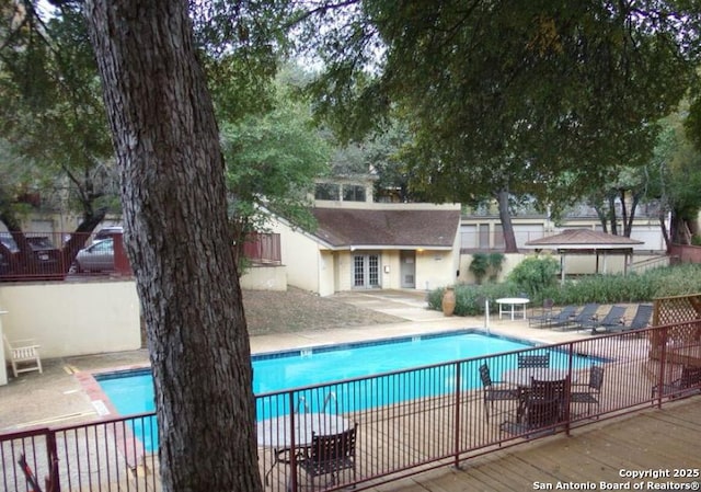 community pool featuring a patio area and fence