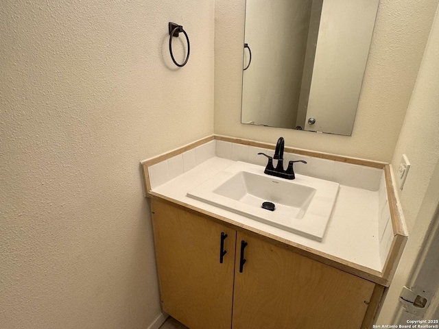 bathroom with a textured wall and vanity