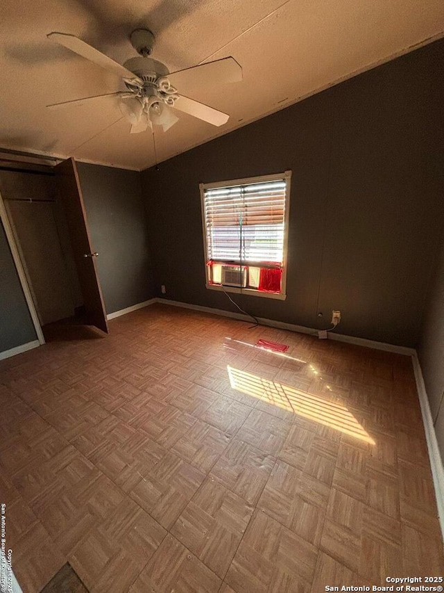 unfurnished bedroom with lofted ceiling, baseboards, and a ceiling fan