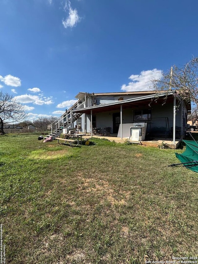 back of property featuring a yard and a patio area