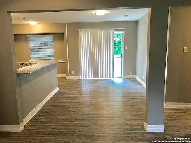 empty room featuring baseboards and wood finished floors