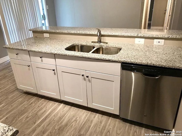 kitchen featuring a sink, light wood-style floors, and dishwasher