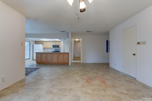 unfurnished living room featuring a textured ceiling, visible vents, and a ceiling fan