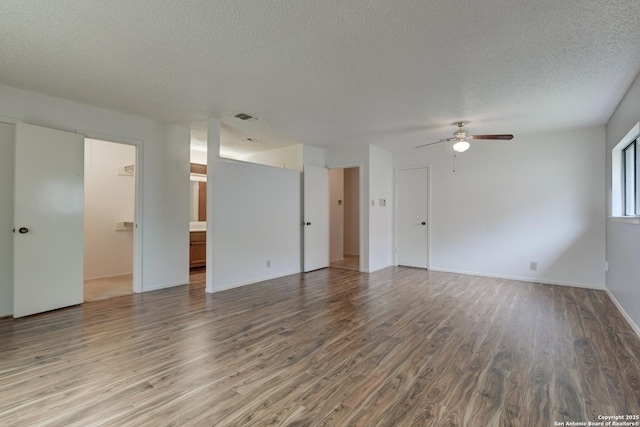 empty room with a ceiling fan, a textured ceiling, visible vents, and wood finished floors