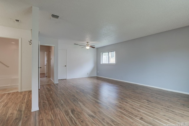 empty room featuring ceiling fan, baseboards, and wood finished floors