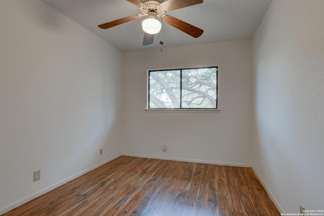 empty room featuring a ceiling fan, baseboards, and wood finished floors