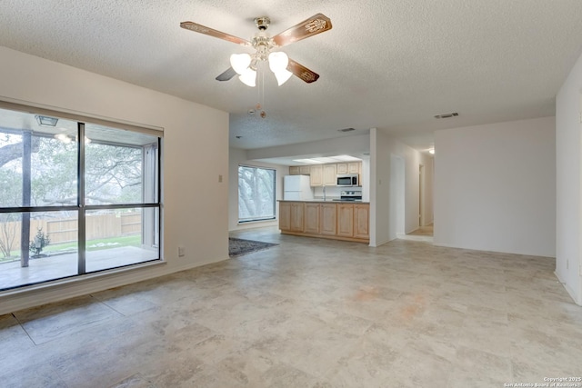 unfurnished living room with visible vents, ceiling fan, and a textured ceiling