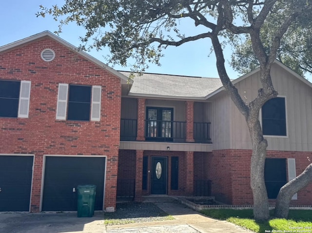 view of front of property featuring an attached garage, a balcony, brick siding, a shingled roof, and driveway