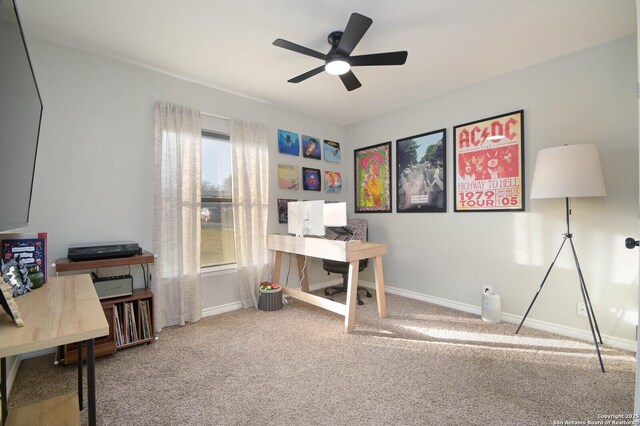 carpeted office featuring a ceiling fan and baseboards