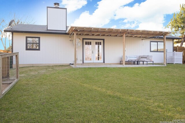 back of property featuring french doors, a yard, a chimney, a patio, and an outdoor living space