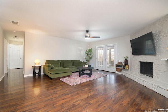 living room featuring a fireplace, wood finished floors, visible vents, baseboards, and french doors