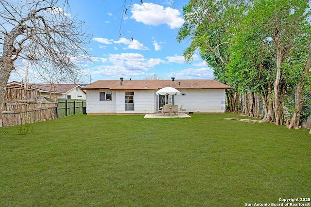 back of property with fence, a lawn, and a patio