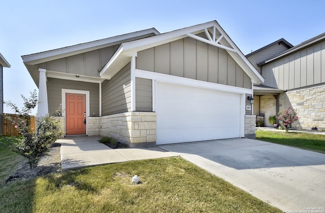 craftsman house with a garage, stone siding, board and batten siding, and driveway