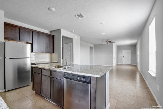 kitchen with appliances with stainless steel finishes, visible vents, a sink, and light tile patterned floors