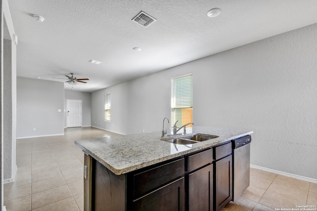 kitchen with visible vents, a sink, a kitchen island with sink, dark brown cabinets, and stainless steel dishwasher