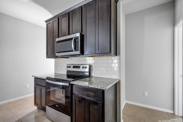 kitchen featuring baseboards, tasteful backsplash, appliances with stainless steel finishes, and dark brown cabinets