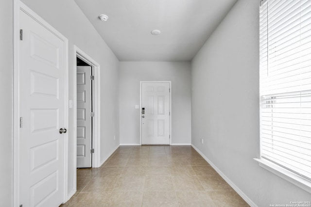 foyer featuring baseboards and light tile patterned floors