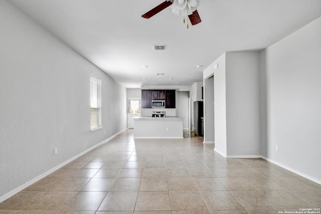 unfurnished living room featuring a ceiling fan, visible vents, baseboards, and light tile patterned flooring