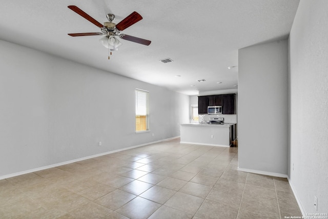 unfurnished living room with light tile patterned floors, baseboards, visible vents, and ceiling fan