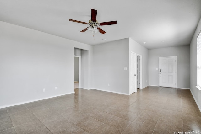 spare room featuring ceiling fan and baseboards