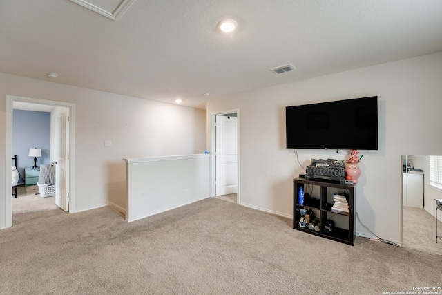 carpeted living room with recessed lighting and visible vents