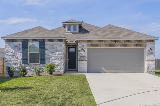 view of front of property with a garage, a shingled roof, concrete driveway, stone siding, and a front yard