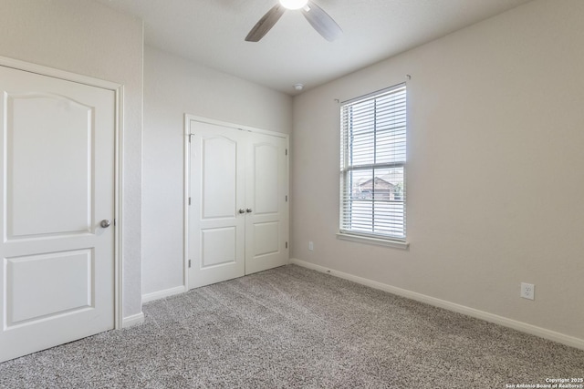 unfurnished bedroom featuring carpet, a ceiling fan, and baseboards