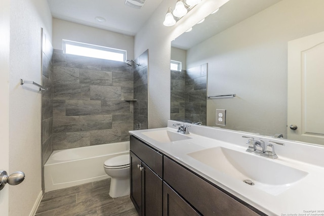 bathroom with double vanity, wood finished floors, a sink, and toilet