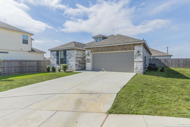 view of front of house featuring an attached garage, a front yard, fence, stone siding, and driveway