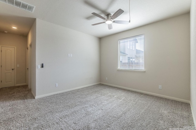 unfurnished room featuring carpet, visible vents, ceiling fan, a textured ceiling, and baseboards