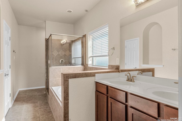 bathroom with double vanity, a stall shower, a sink, tiled tub, and tile patterned floors