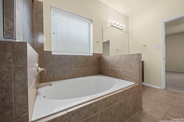 bathroom featuring baseboards, a bath, and tile patterned floors