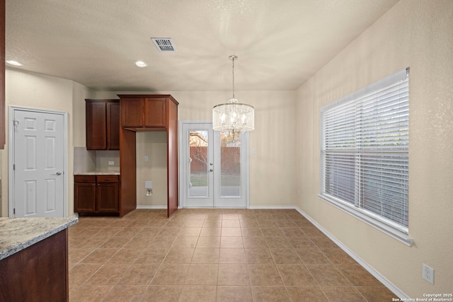 kitchen with visible vents, a notable chandelier, baseboards, and light tile patterned floors