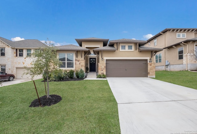 prairie-style house featuring driveway, stone siding, a front yard, and stucco siding