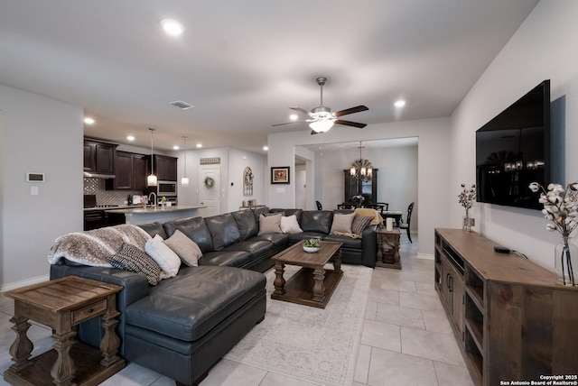 living area featuring light tile patterned floors, recessed lighting, visible vents, baseboards, and ceiling fan with notable chandelier