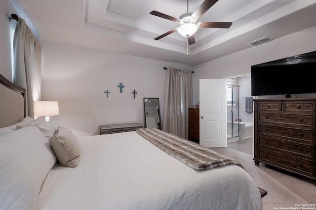 carpeted bedroom with ceiling fan, visible vents, and a raised ceiling