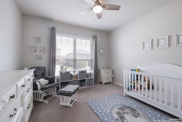 carpeted bedroom featuring a crib, ceiling fan, and baseboards