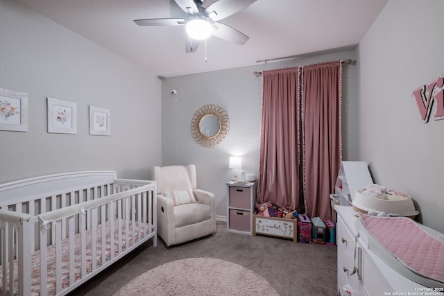 carpeted bedroom with a ceiling fan and a nursery area